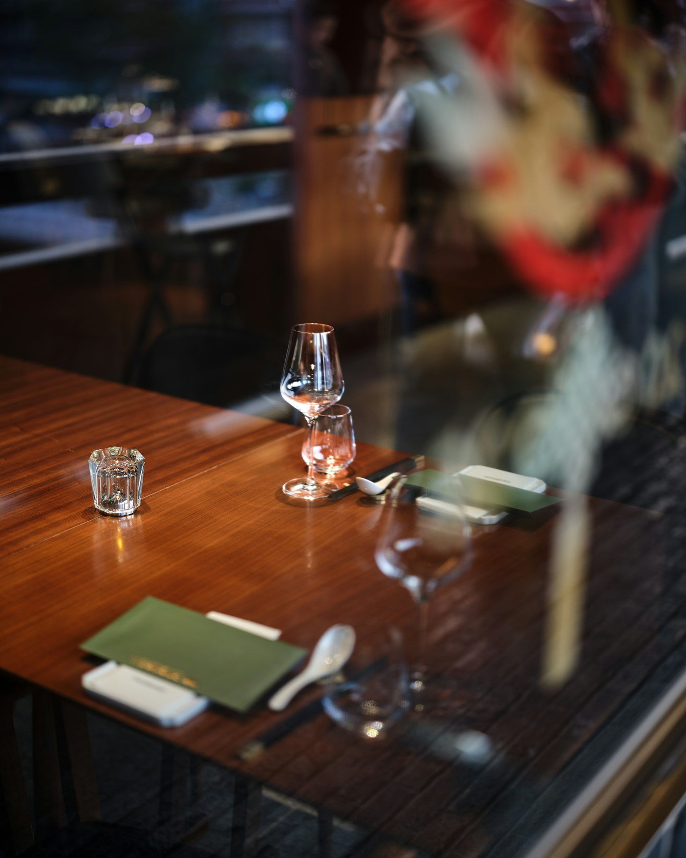 A fine-dining table setting with wine glasses and menus