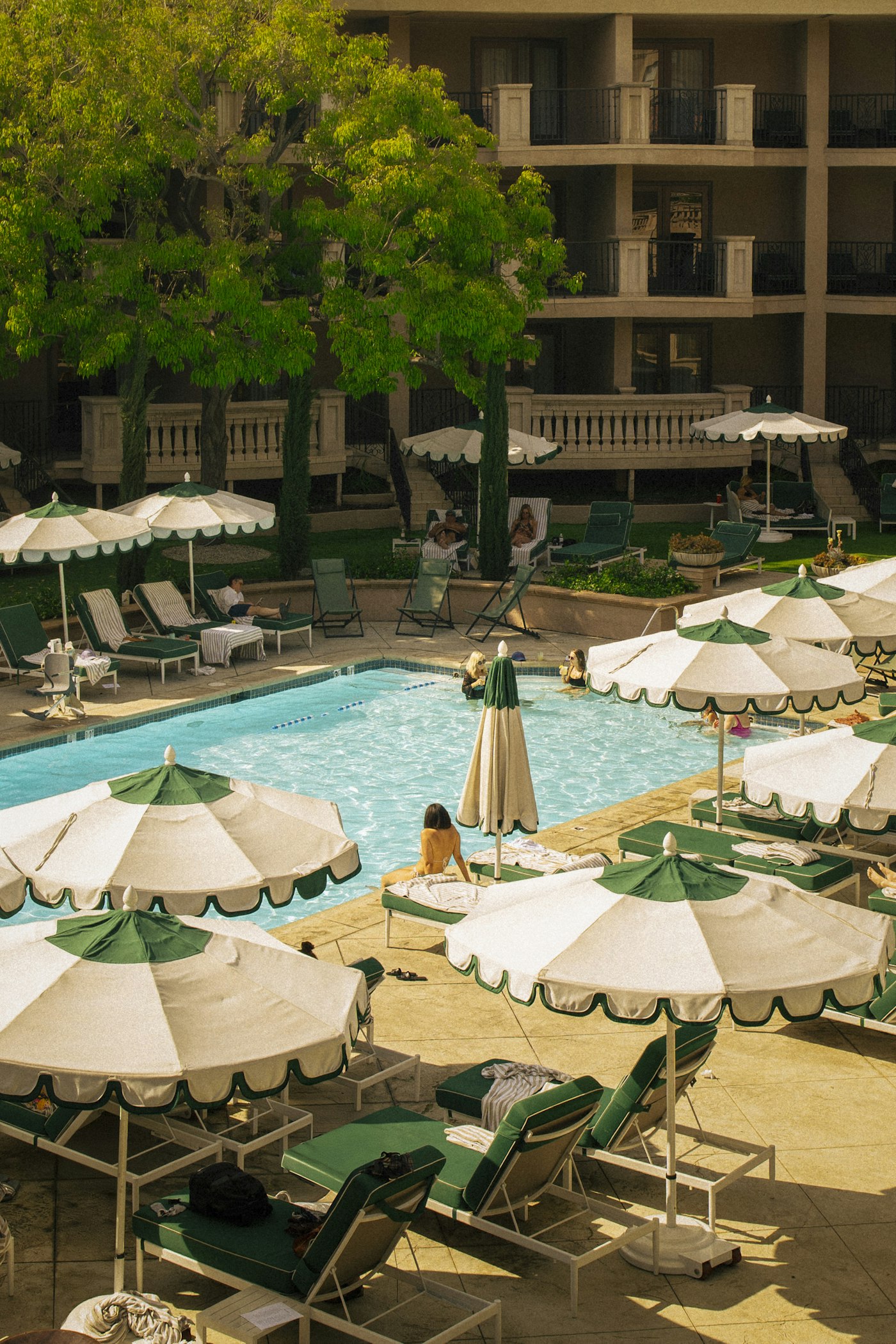 A resort pool with lounge chairs and umbrellas on a sunny day